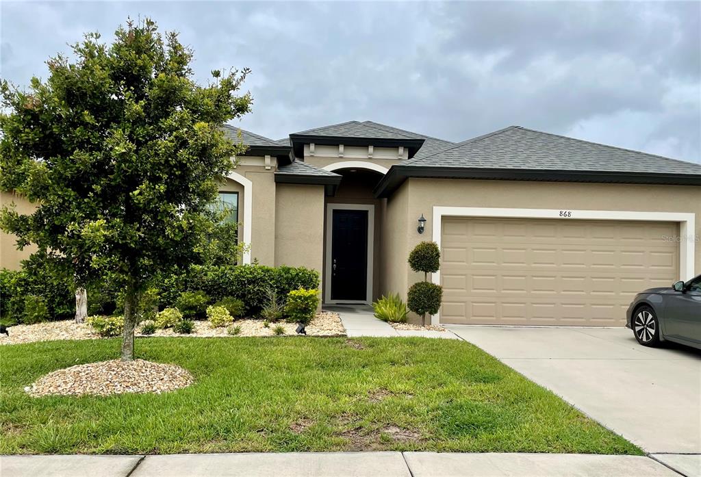 868 Old Windsor Way Spring Hill, FL 34609 - Photo 1 of 20 a front view of a house with garden