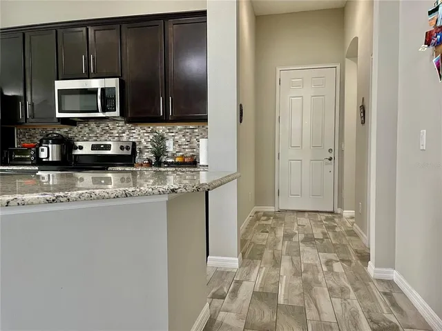 a kitchen with granite countertop a sink and a microwave