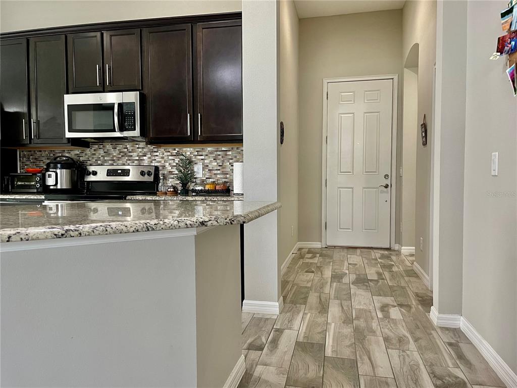 868 Old Windsor Way Spring Hill, FL 34609 - Photo 4 of 20 a kitchen with granite countertop a sink and a microwave