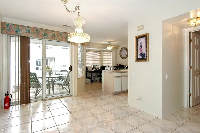 a kitchen with granite countertop a refrigerator a stove a dining table and chairs