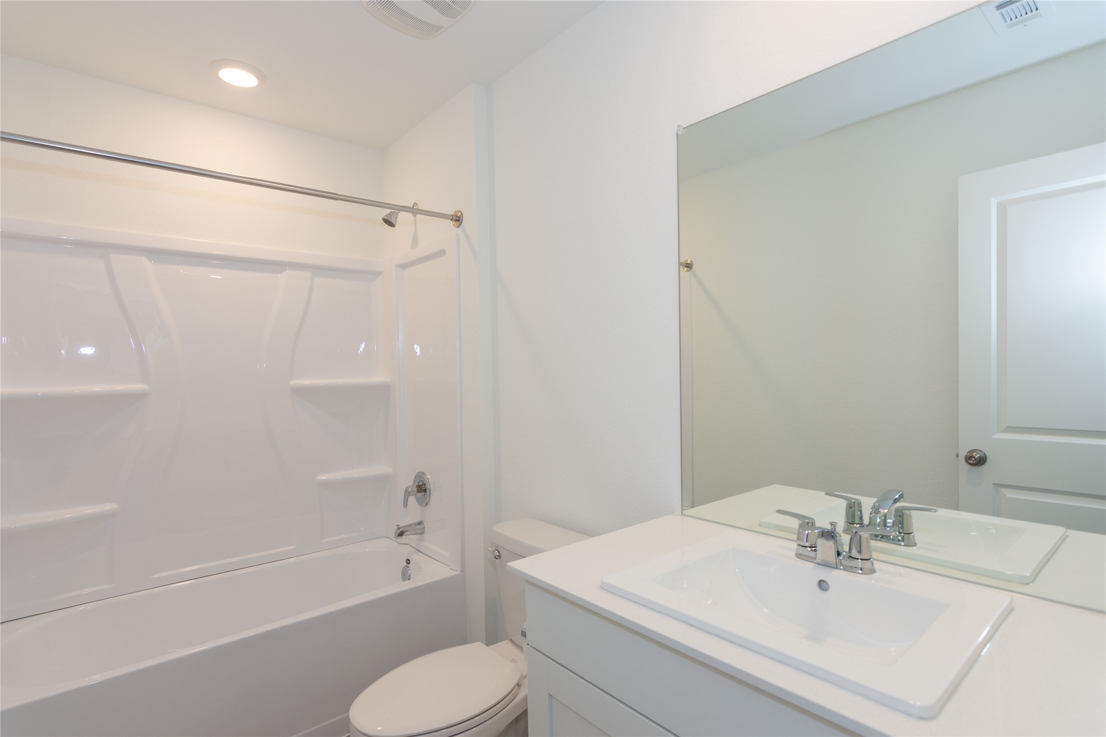 153 Star Packer Lane Jarrell, TX 76537 - Photo 17 of 30 A well-appointed bathroom offers a clean aesthetic with a bright tub-shower combination and a vanity with a large mirror.