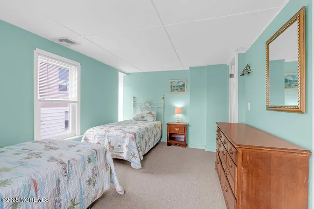 a bedroom with two beds and a dresser