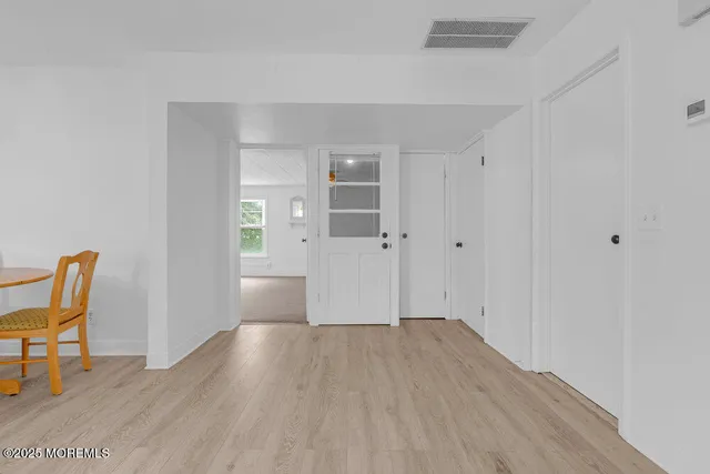 an empty room with wooden floor and furniture