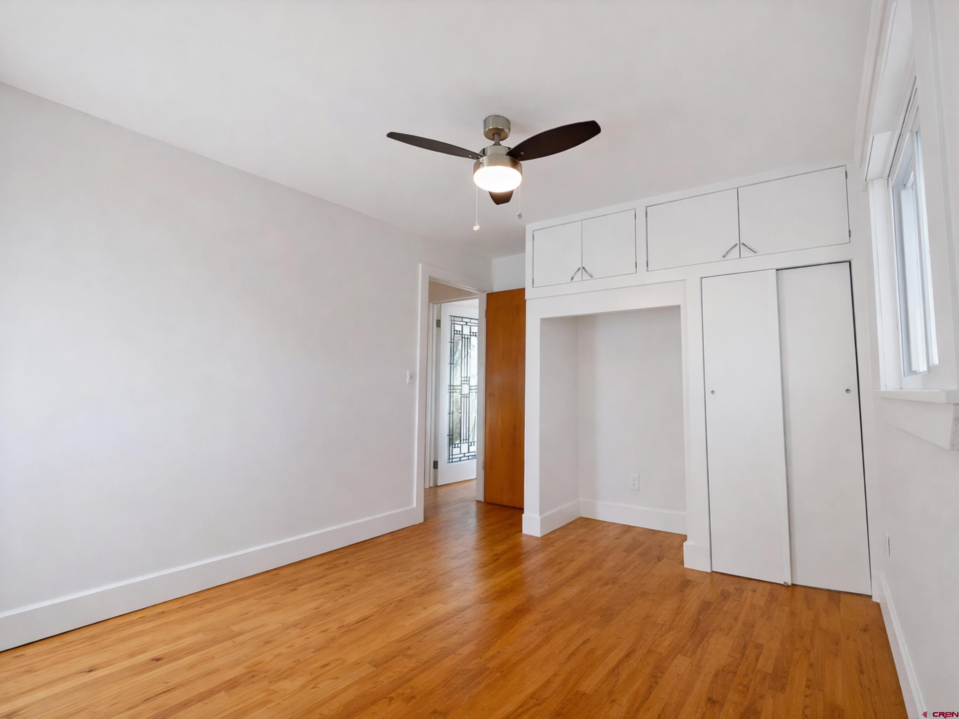 458 Price Road Paonia, CO 81428 - Photo 29 of 44 a view of empty room with wooden floor and ceiling fan