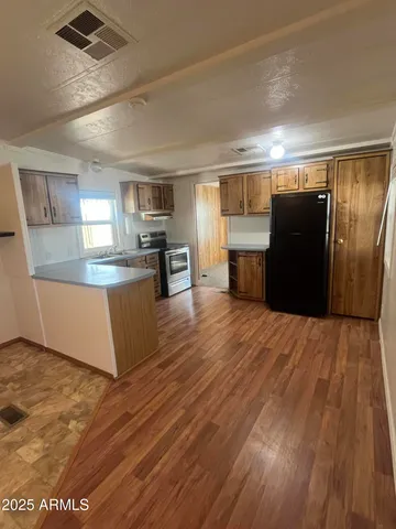 a large kitchen with kitchen island a large counter top space and stainless steel appliances