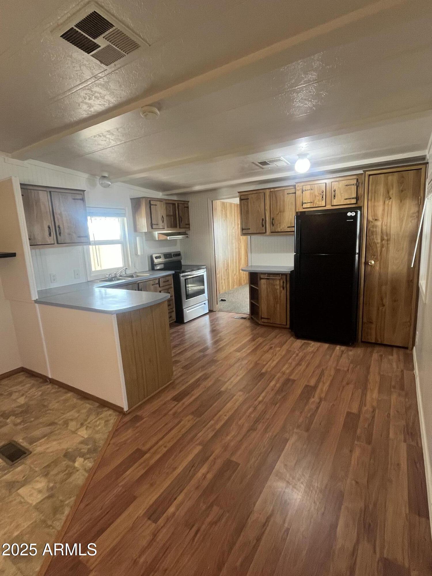 2481 West Broadway Avenue, Unit 31 Apache Junction, AZ 85120 - Photo 9 of 12 a large kitchen with kitchen island a large counter top space and stainless steel appliances