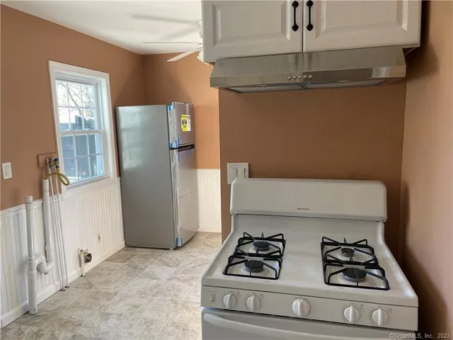 a view of a room with window and a refrigerator