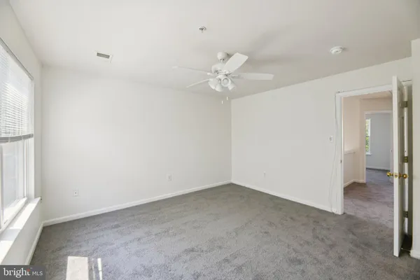 an empty room with a ceiling fan and a window