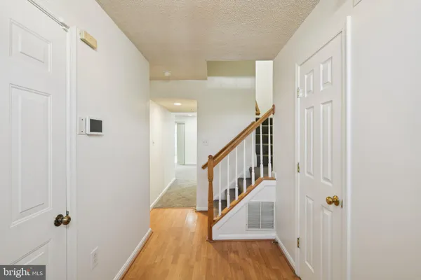 a view of a hallway with wooden floor and entryway