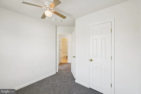 a view of a hallway with a chandelier fan