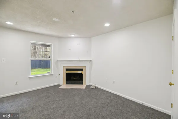 an empty room with windows and fireplace