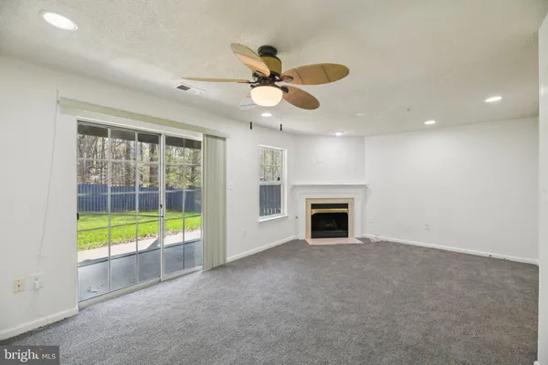 a view of an empty room with a fireplace and a window