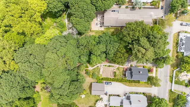 an aerial view of residential houses with outdoor space and trees