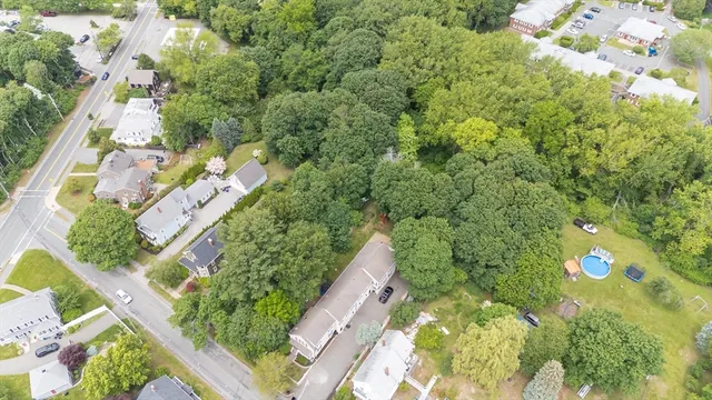 an aerial view of residential houses with outdoor space and trees all around