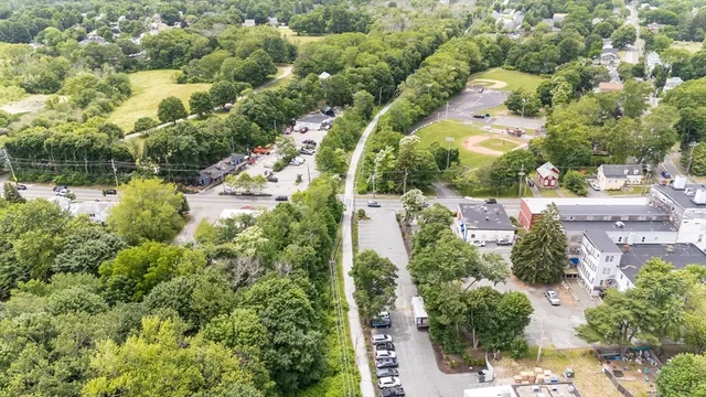 an aerial view of residential house with outdoor space and trees all around
