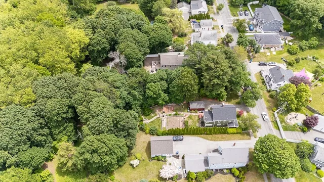 an aerial view of residential house with outdoor space and trees all around