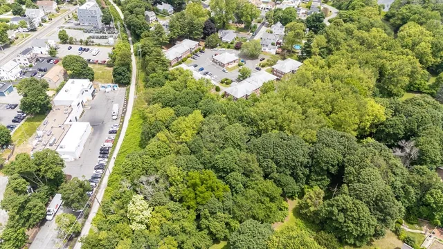 an aerial view of residential house with outdoor space and trees all around