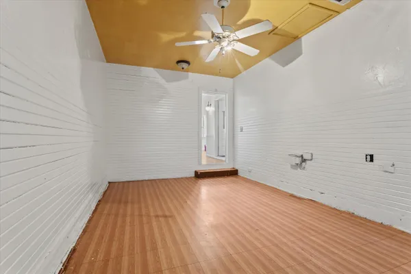 a view of a room with wooden floor and a ceiling fan