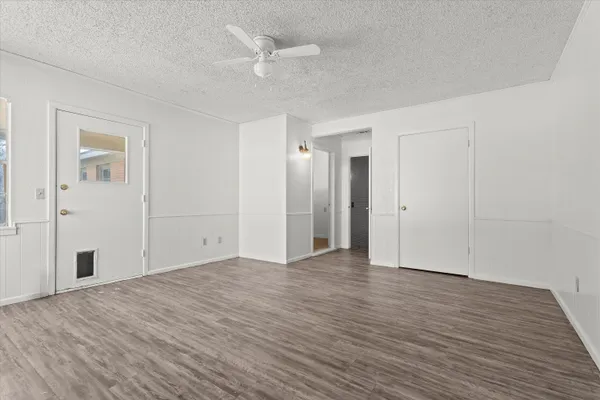 a view of an empty room with wooden floor