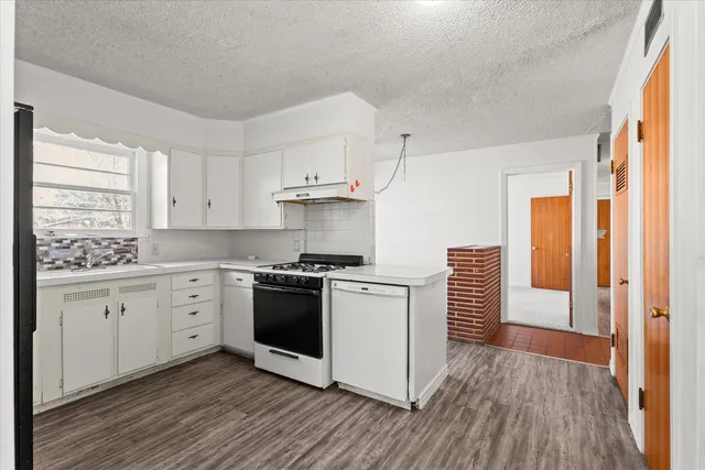 a kitchen with stainless steel appliances a sink cabinets and wooden floor
