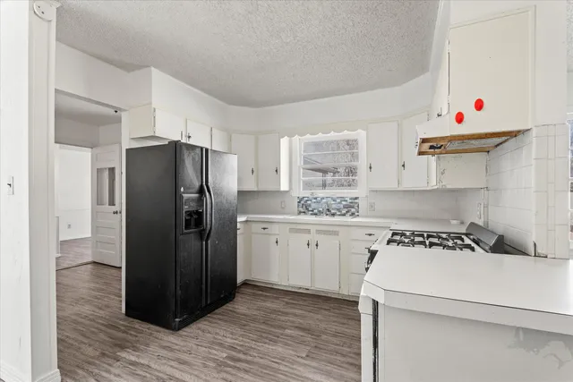 a kitchen with a refrigerator and white cabinets