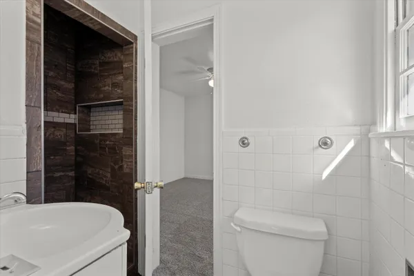 a bathroom with a sink a toilet and shower