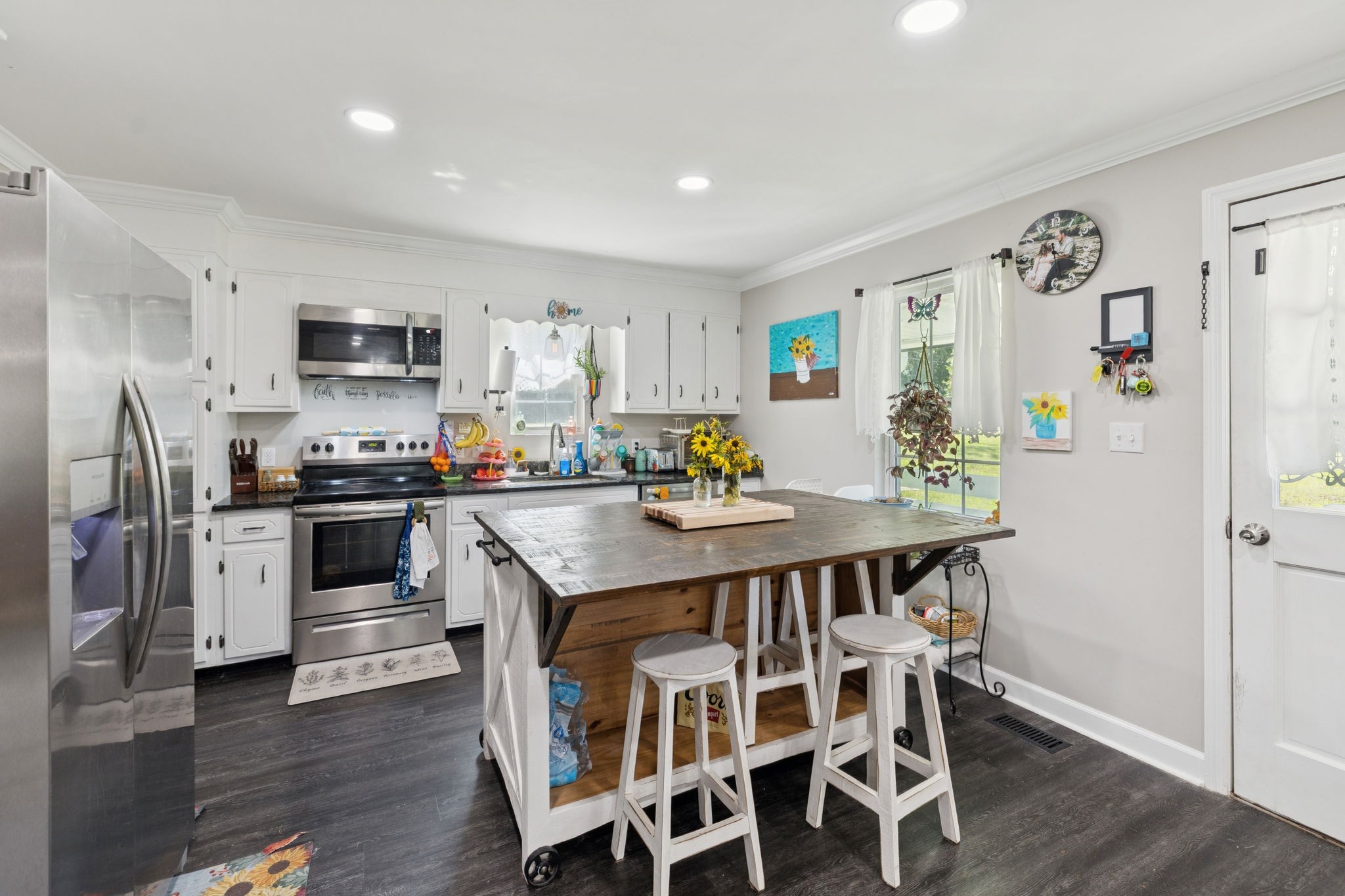 736 Hancock Road Jasper, TN 37347 - Photo 14 of 42 a kitchen with stainless steel appliances kitchen island granite countertop a refrigerator a stove a microwave oven a sink dishwasher and white cabinets with wooden floor