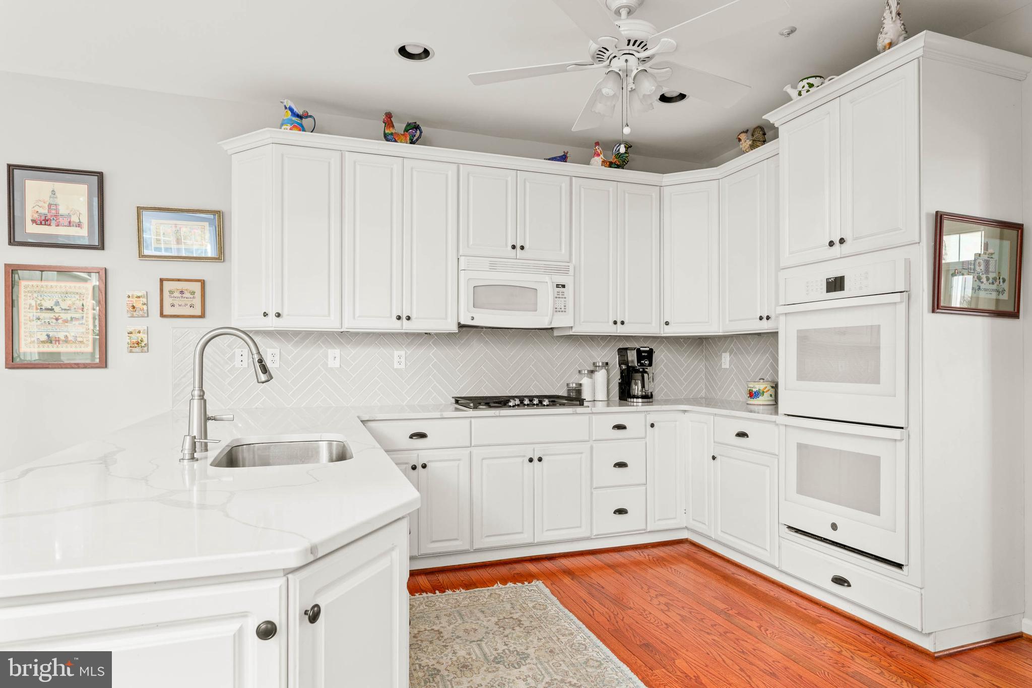 4 Riders Run Newtown Square, PA 19073 - Photo 16 of 64 a kitchen with granite countertop white cabinets and white appliances