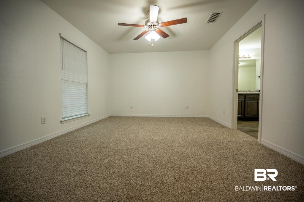 15874 Carver Road, Unit C Foley, AL 36535 - Photo 12 of 18 Carpeted spare room with ceiling fan