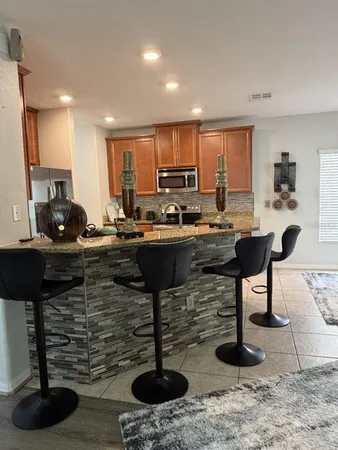 a kitchen with a sink a stove and chairs