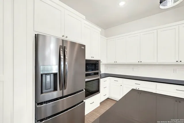a kitchen with granite countertop a sink a stove and cabinets