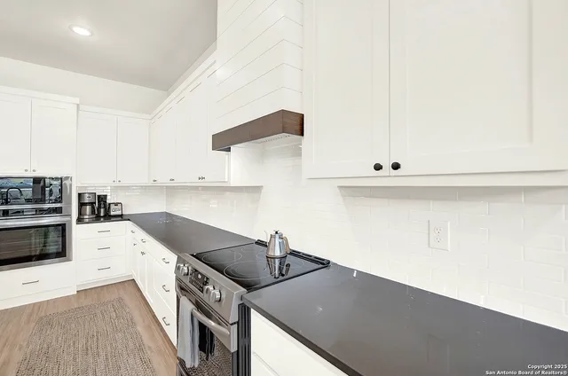 a kitchen with stainless steel appliances kitchen island granite countertop a sink and a refrigerator