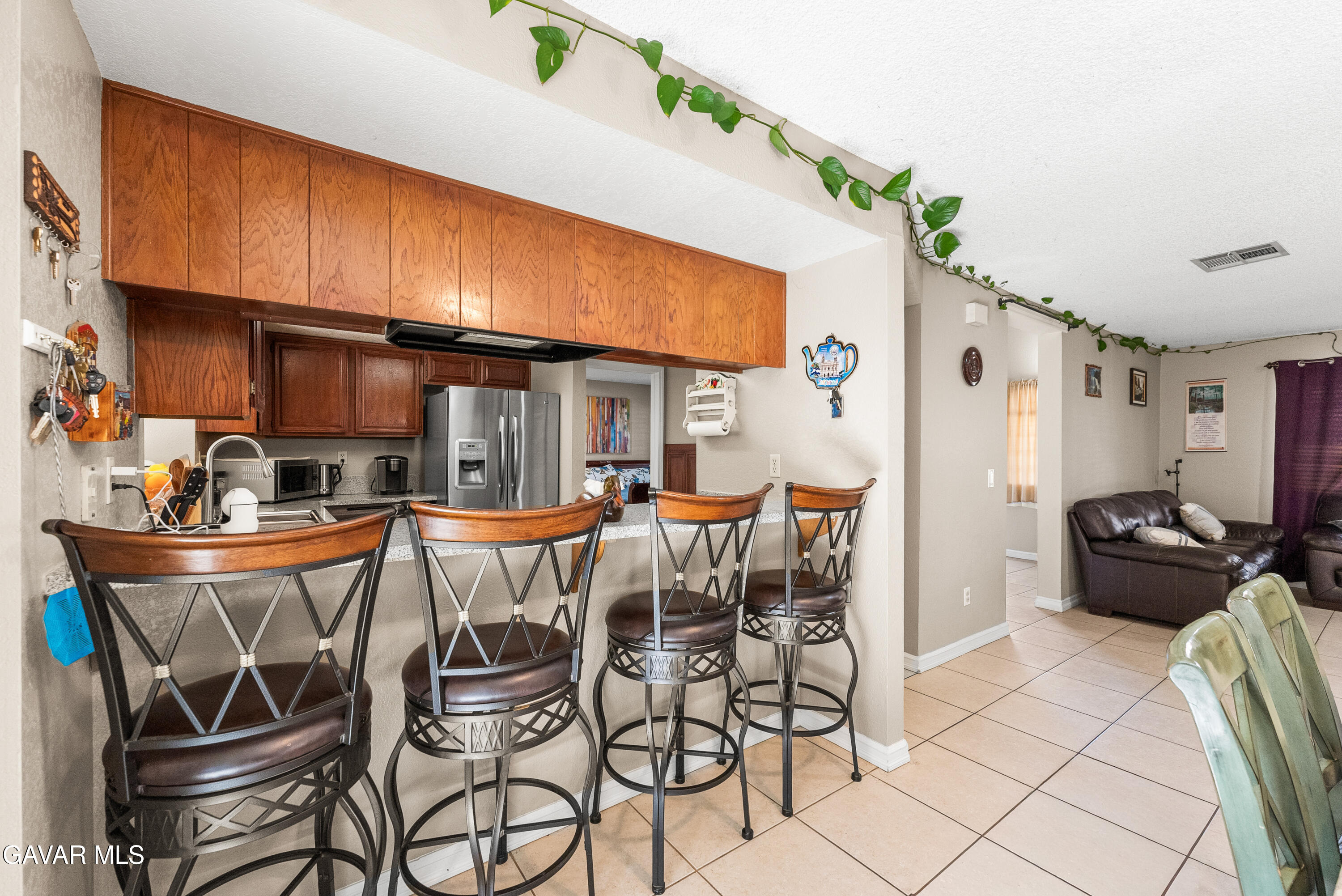 37635 Sandra Lane Palmdale, CA 93550 - Photo 19 of 46 a view of a dining room with furniture a kitchen and chandelier