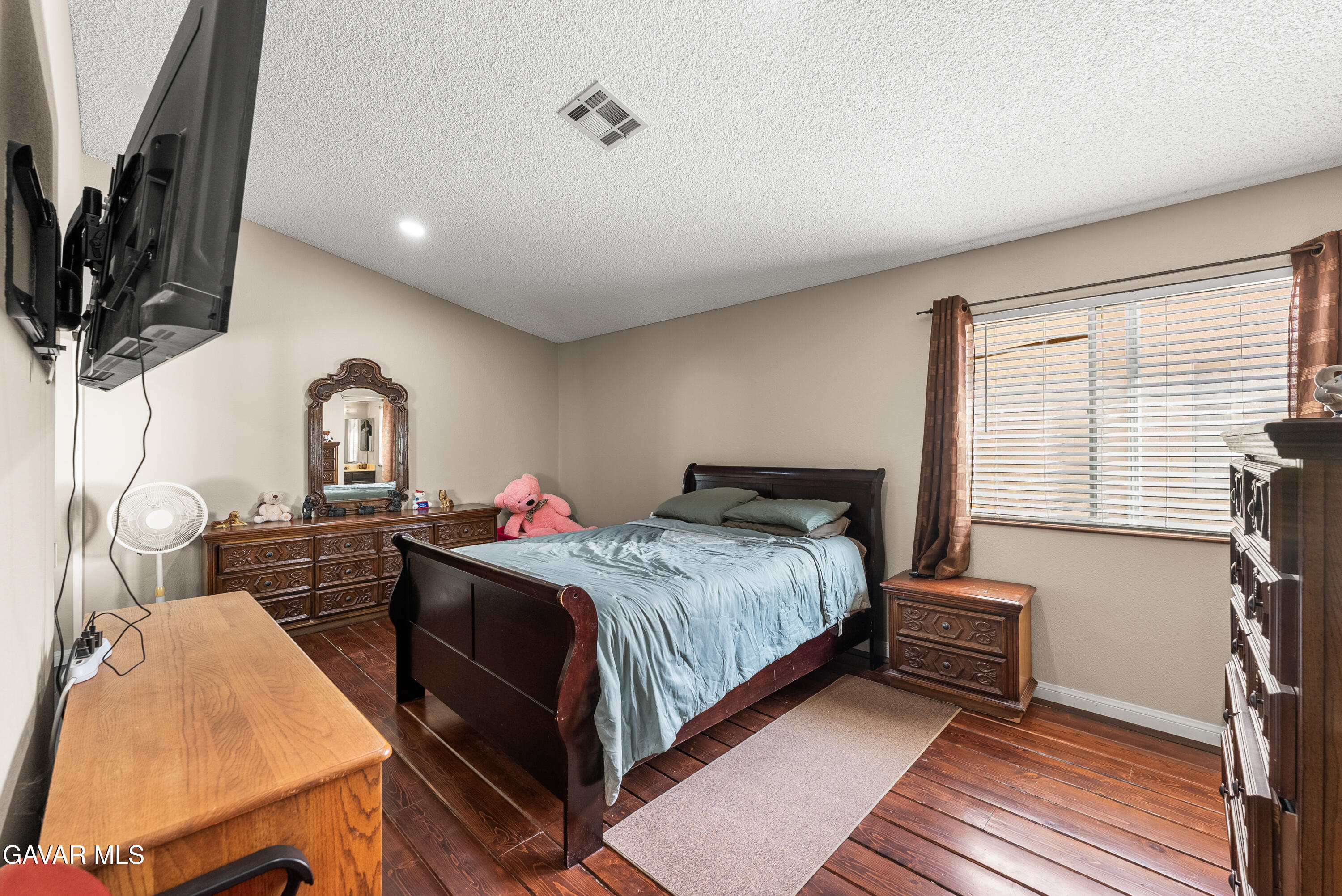 37635 Sandra Lane Palmdale, CA 93550 - Photo 37 of 46 a bedroom with a bed wooden floor and flat screen tv