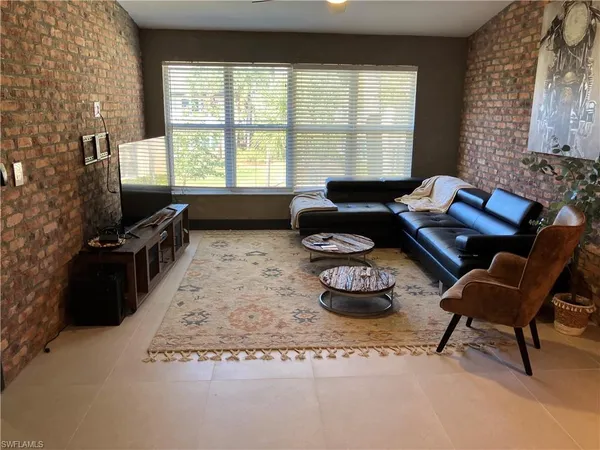 a living room with furniture and a floor to ceiling window