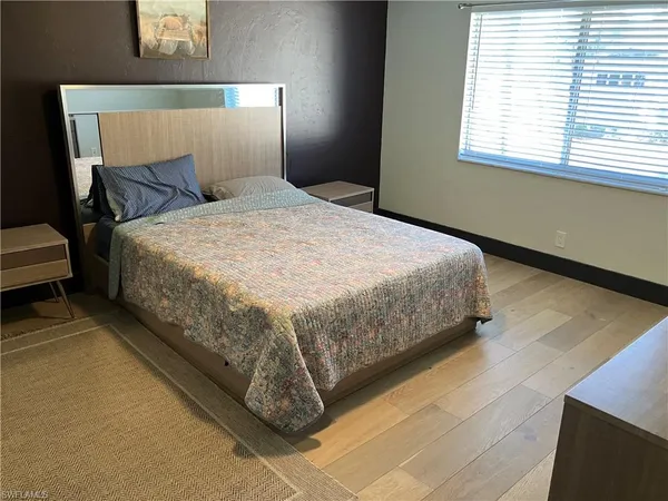 a large bed sitting in a bedroom next to a window