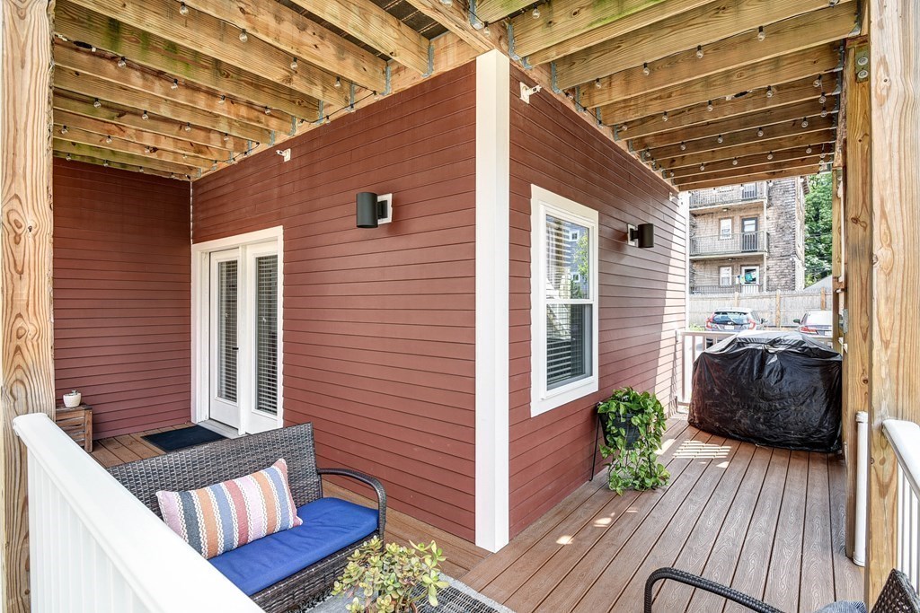 99 Brookley Road, Unit 1 Boston, MA 02130 - Photo 28 of 40 a view of a porch with furniture and wooden floor