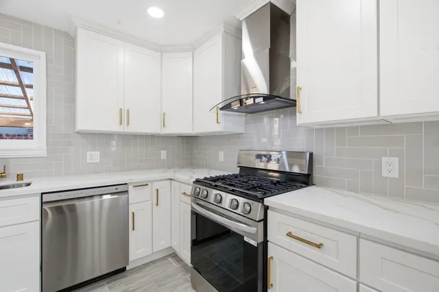 a kitchen with white cabinets and appliances