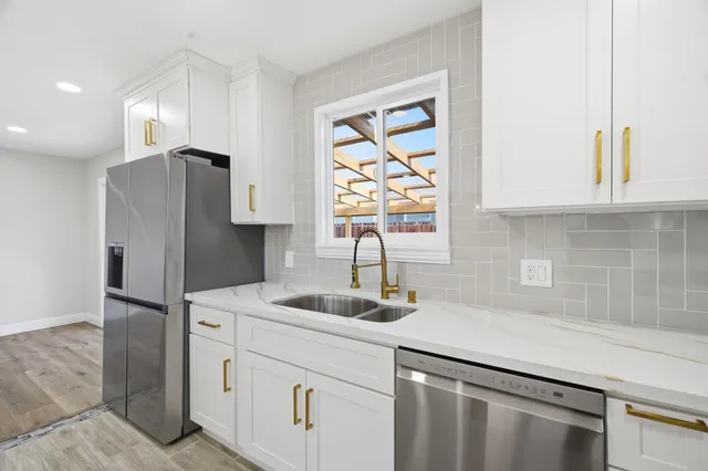 a kitchen with appliances a sink and a window