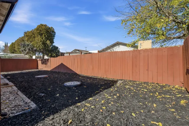 a living room with furniture a flat screen tv and kitchen view