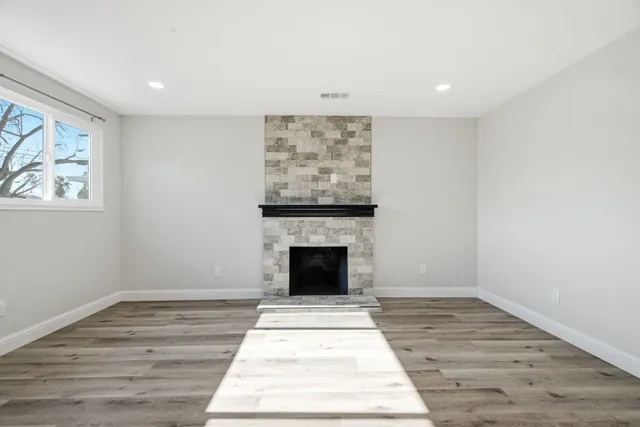 wooden floor fireplace and windows in an empty room