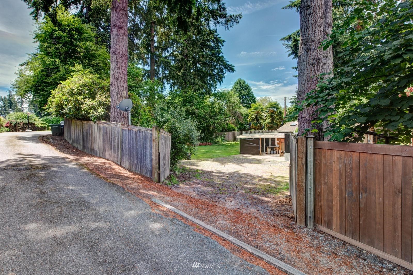 a view of a yard with wooden fence and trees