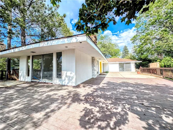 a view of a house with a yard and potted plants