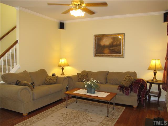 2509 Spruce Shadows Lane Raleigh, NC 27614 - Photo 5 of 21 Cozy living room with gas log fireplace, hardwood floor and a ceiling fan