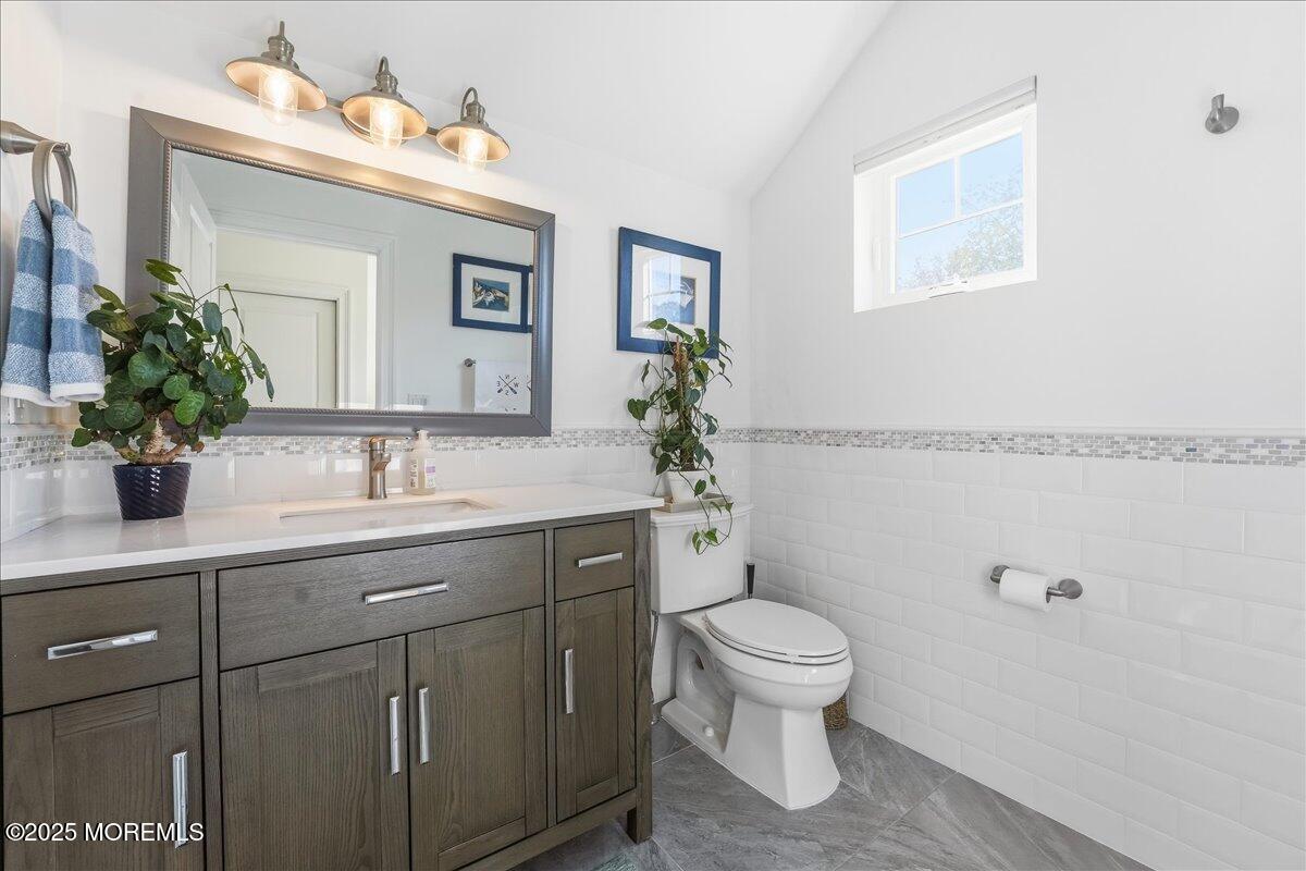 26 Ralph Street Highlands, NJ 07732 - Photo 27 of 51 a bathroom with a granite countertop toilet a sink and a mirror