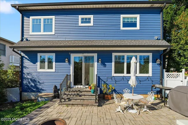 a brick house with table and chairs in front of house