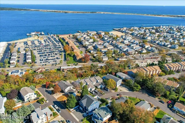 an aerial view of a city with lots of residential buildings and ocean view in back