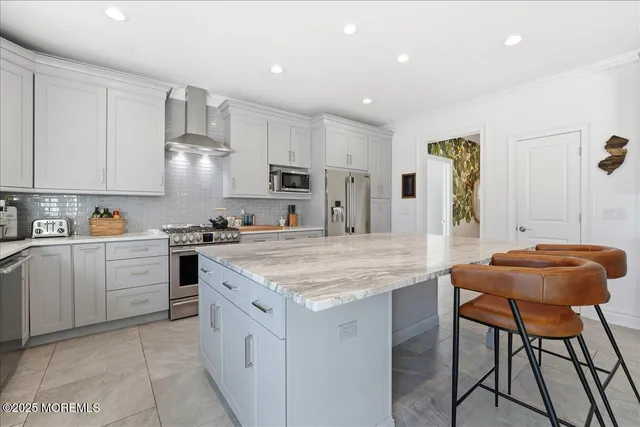 a kitchen with stainless steel appliances granite countertop a table chairs sink and cabinets