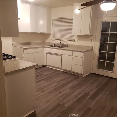 a view of kitchen with wooden floor and cabinets