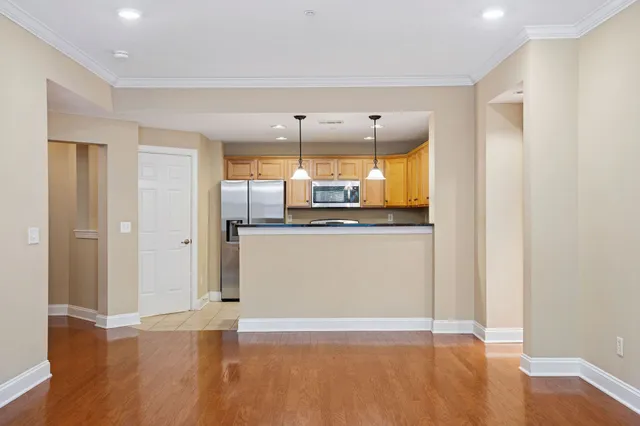 a view of a kitchen with a fridge and wooden floor